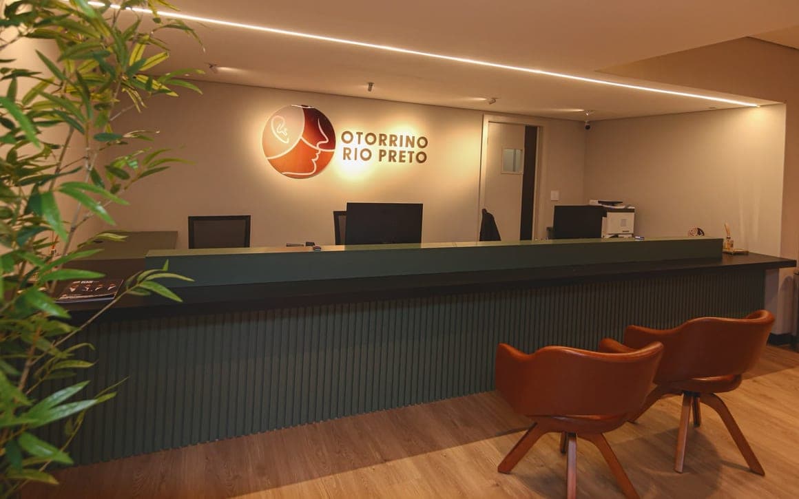 Balcão da recepção com poltronas ao lado